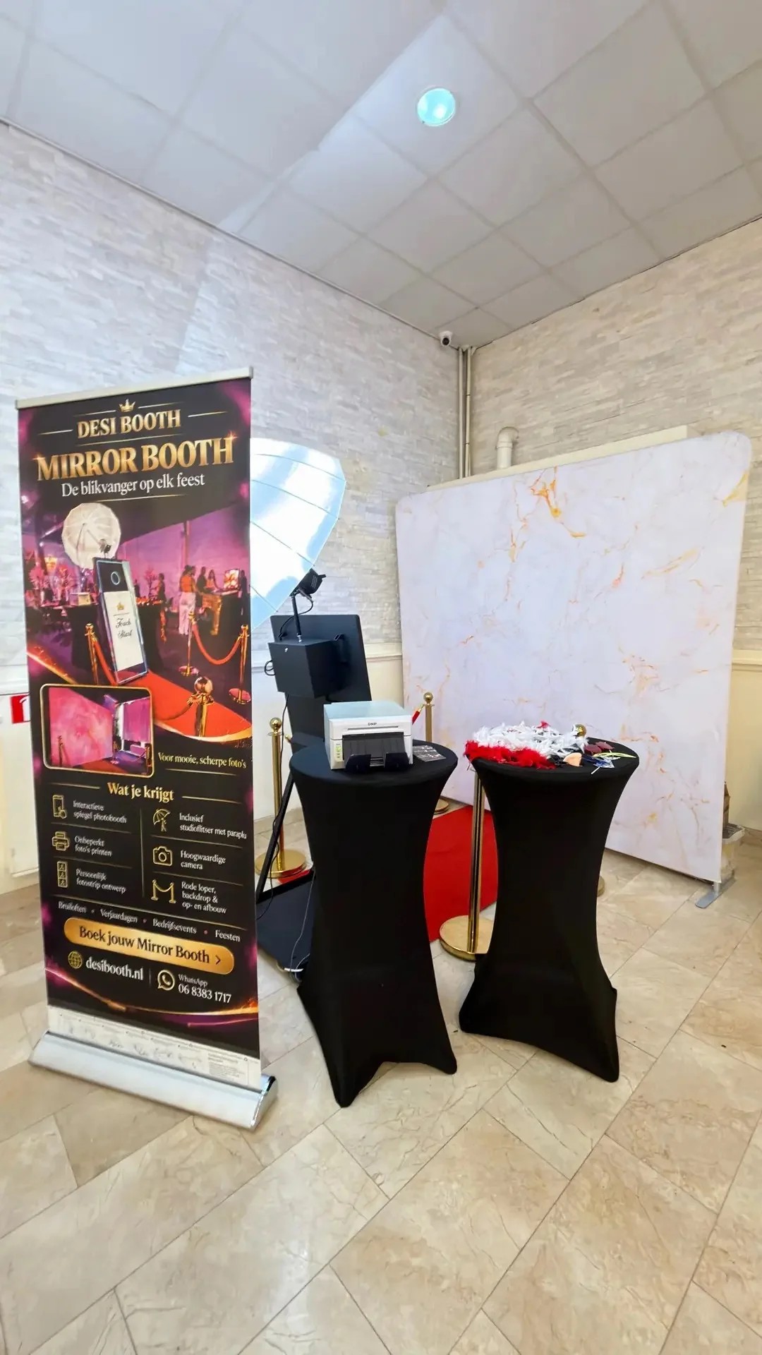 Desi Booth setup met marmeren achtergrond en roll-up banner